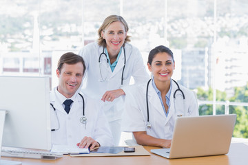 Medical staff working on a laptop and a computer