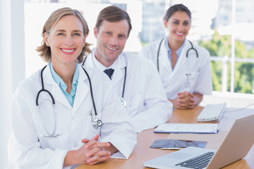 Fototapeta premium Cheerful doctors posing at their desk