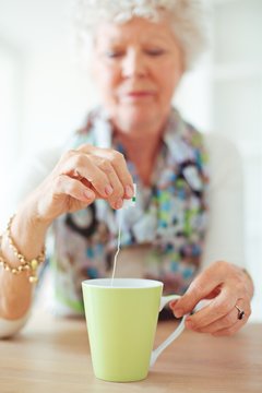 Old Lady Holding A Tea Bag