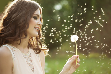 Beautiful woman blowing a dandelion