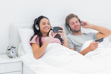 Couple listening to music in their bed