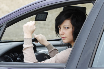 JEUNE FEMME ENERVEE AU VOLANT DE SA VOITURE