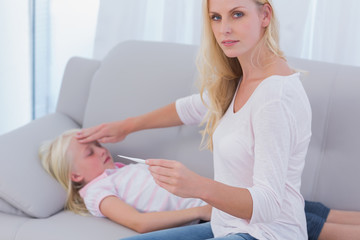 Mother taking her daughter's temperature