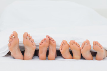 Family on the bed showing their feet