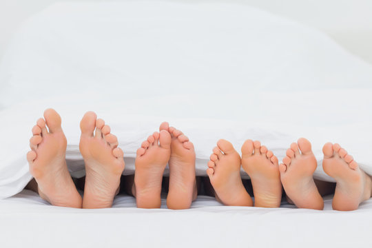Family on the bed showing their feet