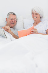 Mature woman showing her book to husband