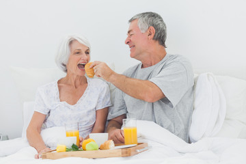 Obraz na płótnie Canvas Man giving wife a croissant to wife