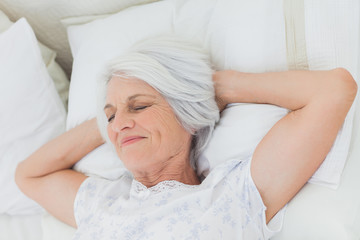 Peaceful woman relaxing in bed
