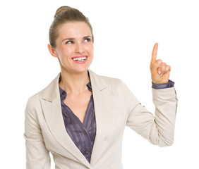 Happy business woman pointing up on copy space