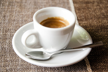 Cup of espresso over brown tablecloth