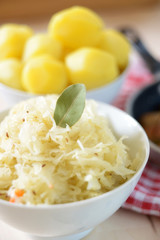 Sauerkraut, Kartoffeln und Würstchen im Hintergrund