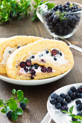 Sweet roll and a glass with fresh blueberry