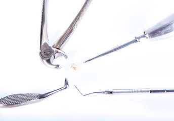 Obraz premium Dental tools around real extracted tooth, with caries