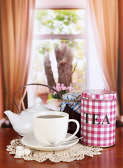 Jar and cup of tea on table in room