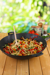 Noodles with vegetables on wok on nature background background