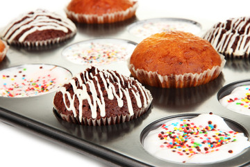 Tasty muffin cakes in baking tray close up