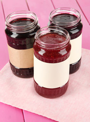 Tasty jam in banks on table