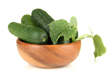 Tasty green cucumbers in wooden bowl, isolated on white