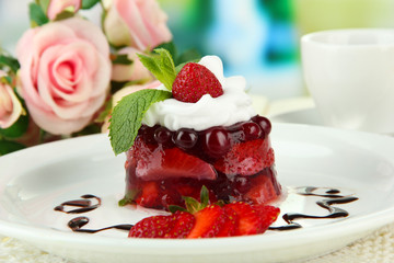 Tasty jelly dessert with fresh berries, on bright background