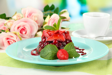 Tasty jelly dessert with fresh berries, on bright background