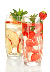 Glasses of fruit drinks with ice cubes isolated on white