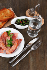 Bacon on plates on wooden table