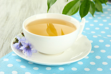 Cup of tea with chicory, on wooden background