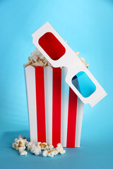 Fototapeta na wymiar Popcorn i okulary 3D na niebieskim tle