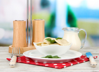 Tasty dumplings on white plate, on bright background