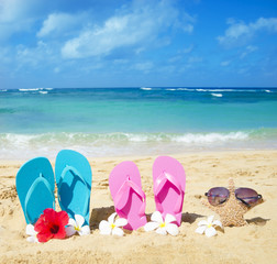 Fototapeta na wymiar Klapki i rozgwiazdy z okulary na piaszczystej plaży