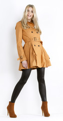 standing woman wearing coat and fashionable brown shoes