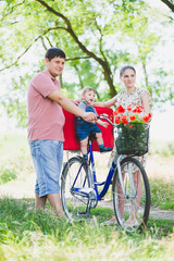 parents carry a child on a bicycle