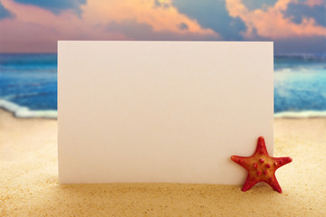 Blank paper with starfish on the sandy beach