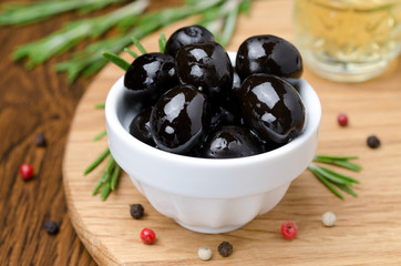 black olives and spices on a wooden board