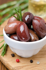 kalamata olives and spices on a wooden board, close-up vertical