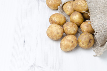 new potatoes in a sack on a white background with space for text