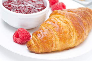 raspberry jam and croissant on a plate