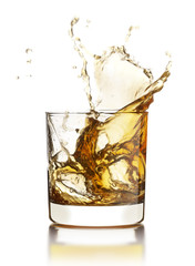 Whisky splashing out of the glass with ice cubes isolated on whi
