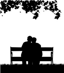 Retired elderly couple sitting on bench in garden or yard