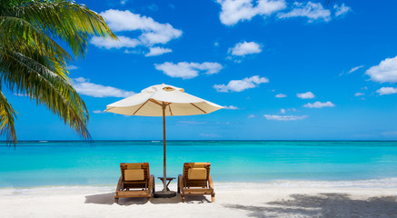 two deckchairs on the idyllic white beach in front of the turquo