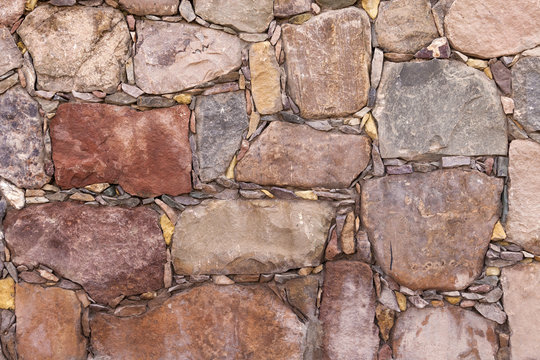 Background of a wall of terracotta colored stones.