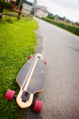Longboard by the asphalt road at the border of a village