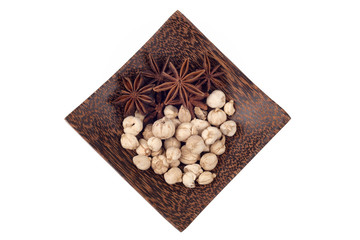 Star anise and camphor seeds on wood plate