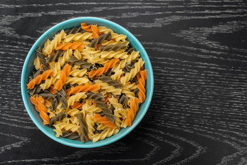 Fusilli in blue bowl on wood table