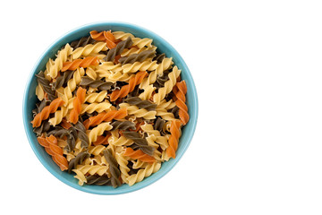 Fusilli in blue bowl on white background