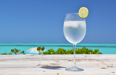 Glass of water on the tropical beach