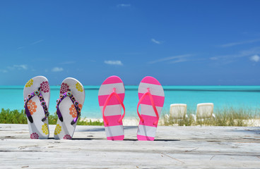 Two pairs of flip-flops against Atlantic. Exuma, Bahamas