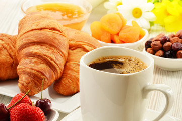 Breakfast with croissants cup of coffee and fruits