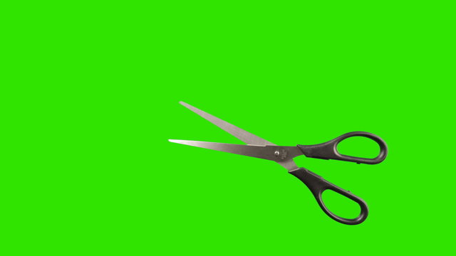 Real scissors animated on a green background