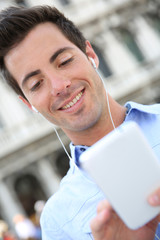 Smiling handsome guy talking on the phone with handsfree